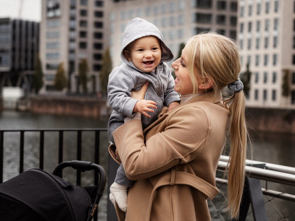 Uśmiechnięta mama trzymająca malucha na rękach